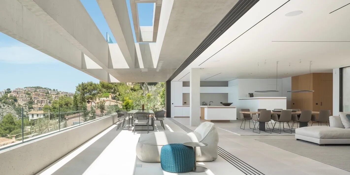 Contemporary hillside villa with an open terrace overlooking the landscape, opening onto a light-filled living and dining space
