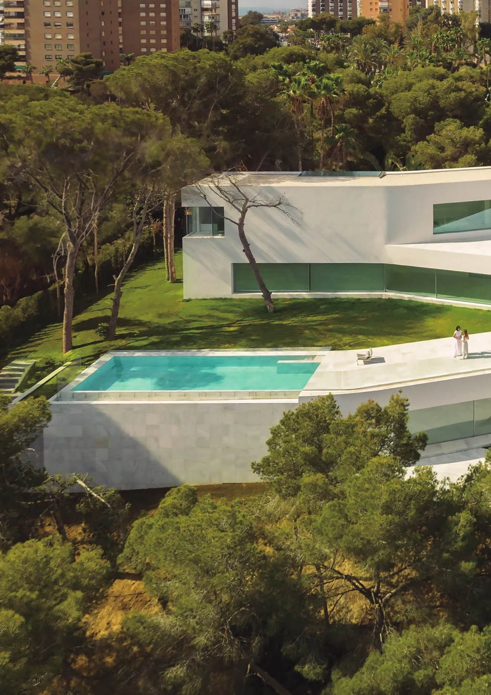 Casa Sabater — cantilevered white volume glazed in Sosoares OS minimalist sliding units above the pool