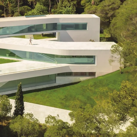 Casa Sabater seen from the garden, its long glazed façade built from Sosoares OS minimalist sliding units