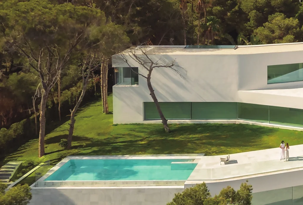 Casa Sabater — cantilevered white volume glazed in Sosoares OS minimalist sliding units above the pool
