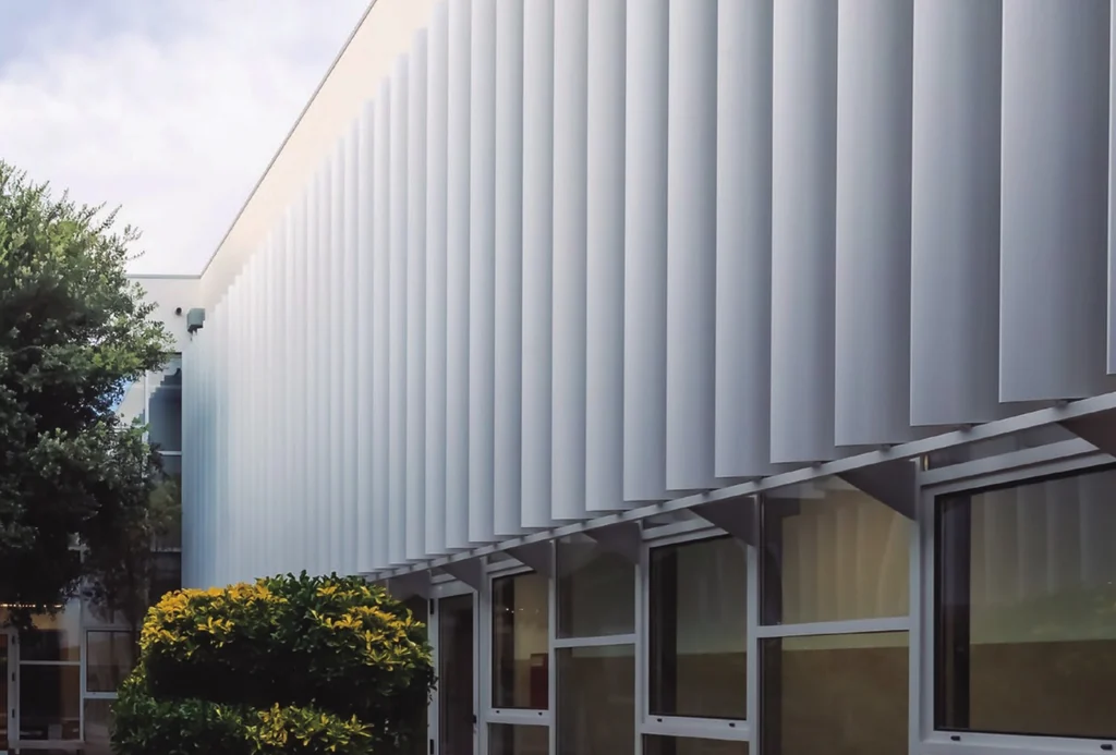 ISCAA, Aveiro — a full-height QS louvre screen wrapping the walkway elevation